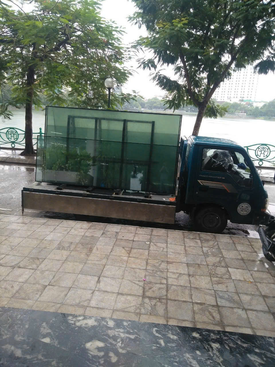 Xe tải chở các tấm kính đến điểm giao hàng bên đường